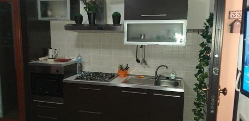 a kitchen with a sink and a stove at Airport Orchid in Olbia