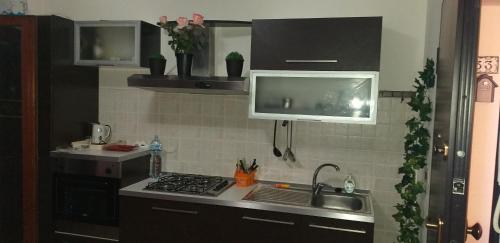 a kitchen with a sink, stove, and dishwasher at Airport Orchid in Olbia