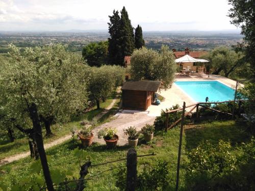 a villa with a swimming pool in a garden at Villa Pilar in Toscana con piscina ultrapanoramica in Montevettolini