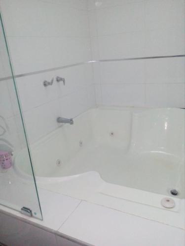 a white bathroom with a tub and a shower at Confort Plaza Hotel in Villavicencio