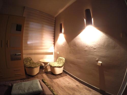 een kamer met 2 stoelen en verlichting aan de muur bij Casa Txep in Vilaller