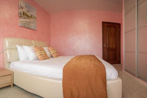 a bedroom with a white bed with pink walls at 2-room Apartment Lux near Centre Wi-Fi Free in Dnipro