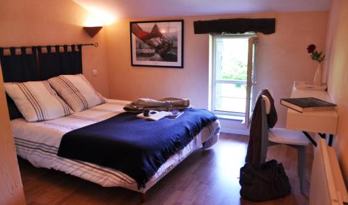 um quarto com uma cama, uma secretária e uma janela em la Ferme aux abeilles em Ambierle