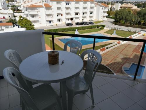 een tafel en stoelen op een balkon met uitzicht bij Albufeira INN - Casa de Viseu - CORAL T1 in Albufeira