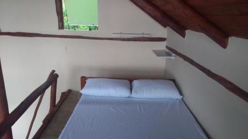 a small room with a bed in a attic at Mirante in Trindade