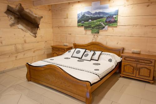 a bedroom with a bed in a log cabin at Leśny Dwór in Murzasichle