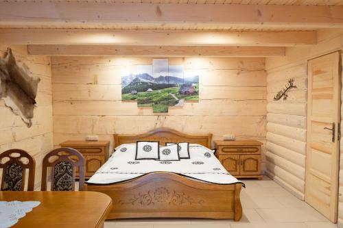 a bedroom with a bed in a log cabin at Leśny Dwór in Murzasichle