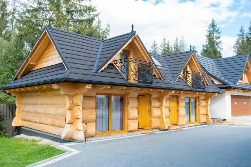 a log cabin with a black roof at Leśny Dwór in Murzasichle