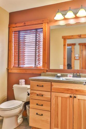 a bathroom with a toilet and a sink and a mirror at Good Ol Days Resort in Nisswa
