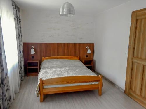 ボルクフにあるPokoje Gościnne Bolkówの部屋に木製のベッドがある寝室