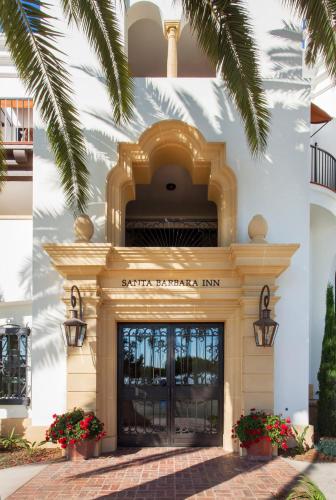 a building with a door and a palm tree at Santa Barbara Inn in Santa Barbara