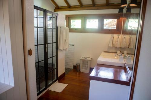 a bathroom with a white sink and a mirror at Excelente casa, pé na areia, no melhor de Arraial! in Arraial d'Ajuda