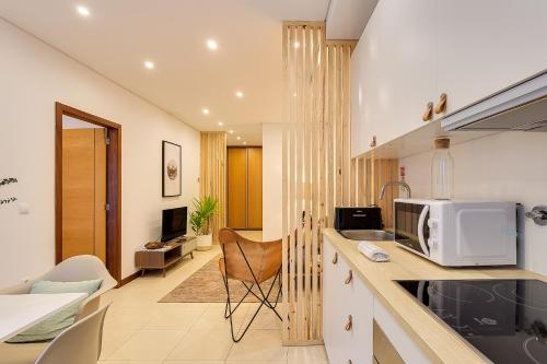 a kitchen with a microwave and a living room at DA'HOME - Marquês Unique Terraza in Porto