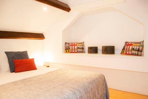 ein Schlafzimmer mit einem Bett und Regalen an der Wand in der Unterkunft DA'HOME - Vitoria Duplex Apartment in Porto