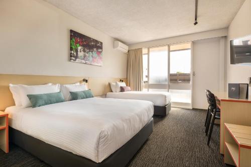 a hotel room with two beds and a desk at Nightcap at Waltzing Matilda Hotel in Springvale
