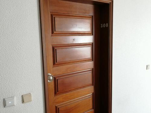 una puerta de madera en una habitación con el número. en Albufeira INN - Casa de Viseu - CORAL T1, en Albufeira
