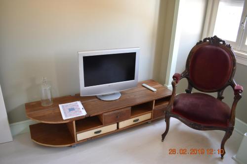 escritorio con monitor y silla en la habitación en ARMAZÉM VILAÇA - Ap. Lavoisier en Coimbra