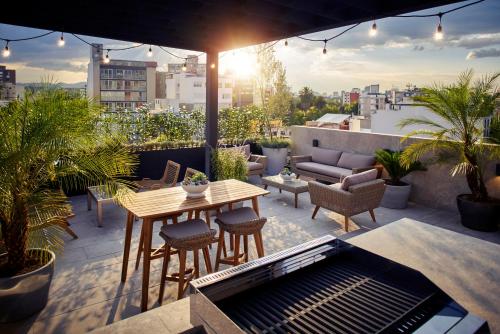 a patio with a table and chairs on a rooftop at Felix by Viadora in Mexico City