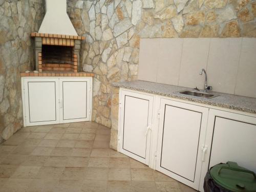 a kitchen with a sink and a stone wall at SOL & MAR in Lagos