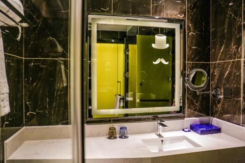 a bathroom with a sink and a mirror at Chao Man Hotel(Guangzhou Pazhou Exhibition Center Chigang Subway Station) in Guangzhou