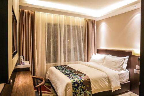 a hotel room with a bed and a window at Chao Man Hotel(Guangzhou Pazhou Exhibition Center Chigang Subway Station) in Guangzhou