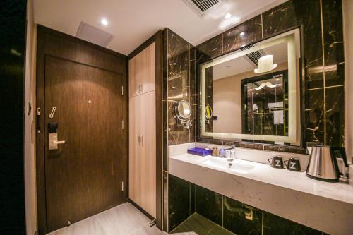 a bathroom with a sink and a mirror at Chao Man Hotel(Guangzhou Pazhou Exhibition Center Chigang Subway Station) in Guangzhou