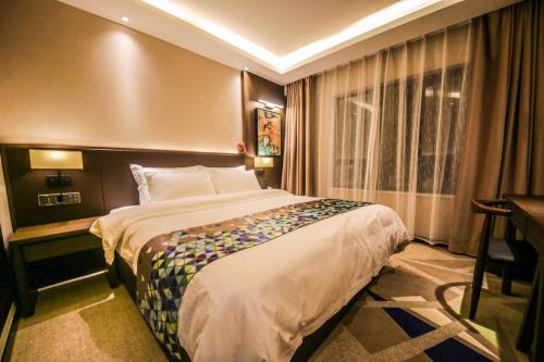 a hotel room with a large bed and a desk at Chao Man Hotel(Guangzhou Pazhou Exhibition Center Chigang Subway Station) in Guangzhou