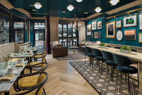 a restaurant with blue walls and tables and chairs at Merrion Row Hotel and Public House in New York