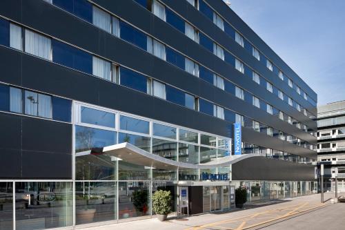 an office building with a large glass facade at Novotel Zurich City West in Zürich