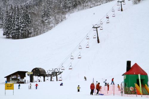a group of people on a ski lift in the snow at Schanze Nozawa in Nozawa Onsen