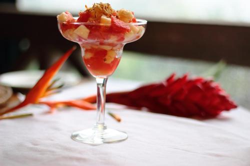 a martini glass with fruit in it on a table at Jungle Bay Dominica in Soufrière