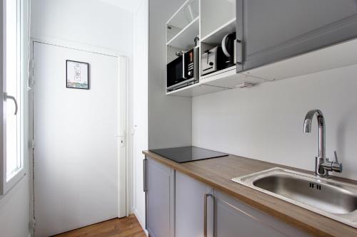 - une cuisine avec un évier et un comptoir dans l'établissement Rent a Room - Residence Meslay, à Paris