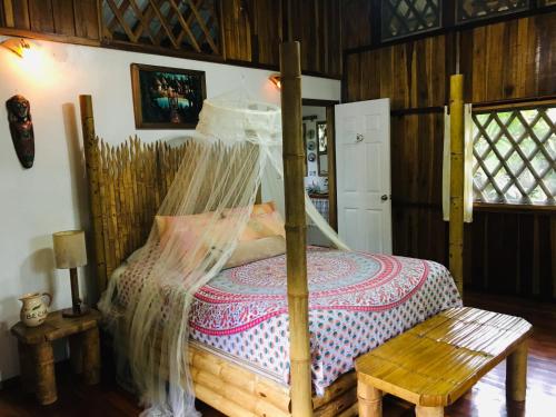
a bed with a wooden headboard and a wooden bedspread at Coral Hill Bungalows in Cahuita
