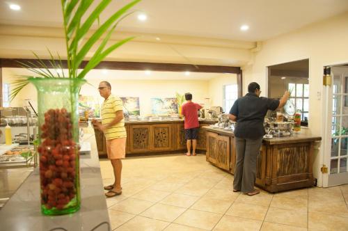 a group of people standing in a kitchen at Coco Palm in Gros Islet