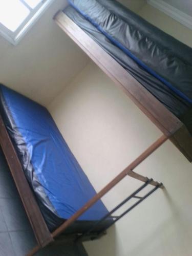 a bunk bed in a room with a blue sheet at Apto 3 qtos Praia Jacaraípe Serra in Serra