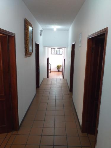 a hallway with white walls and a tile floor at Casa del Peregrino Santo Thomas in Baños