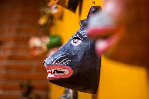 a person holding a black cow head on a door at Hostal Riviera Sucre in Otavalo