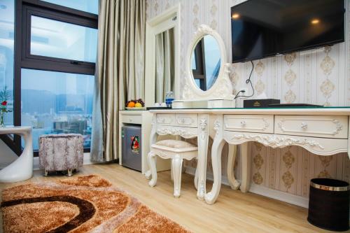 a bathroom with a white vanity and a mirror at Golden Rose Hotel in Da Nang