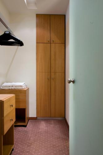 a room with a closet and a wooden cabinet at Capsis Hotel Thessaloniki in Thessaloniki