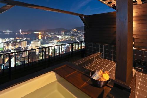 a balcony with a view of a city at night at Hotel Nagasaki in Nagasaki
