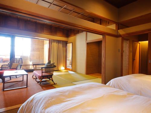 ein Schlafzimmer mit einem Bett und ein Wohnzimmer in der Unterkunft Awaji Hamarikyu in Minamiawaji