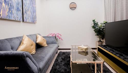 a living room with a couch and a coffee table at Amamas Boutique Hotel Kuching in Kuching