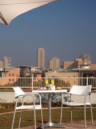a table and chairs with a view of the city at RH Hotel & Apartments - Pretoria in Pretoria