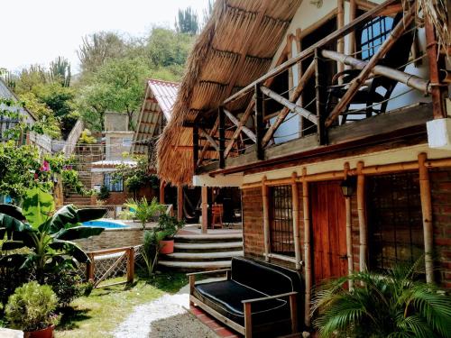 a house with a bench in front of it at Hostal Kaia in Santa Marta