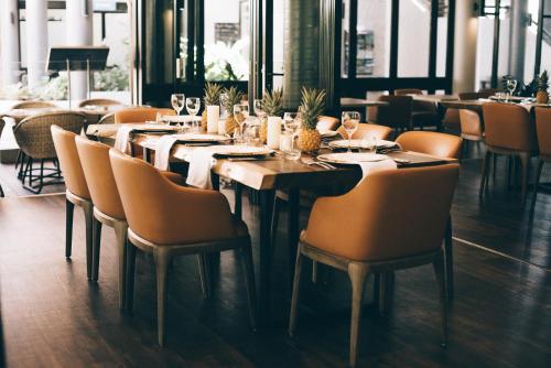 a dining room with a table and chairs with glasses at Mantra Club Croc in Airlie Beach