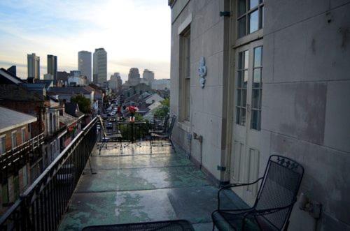 einen Balkon mit einem Stuhl in einem Gebäude mit einer Stadt in der Unterkunft Lafitte Hotel & Bar in New Orleans