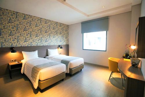 a hotel room with two beds and a window at BW inn Belitung in Tanjungpandan