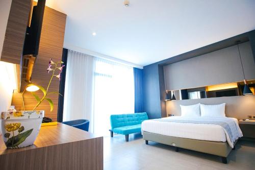a bedroom with a bed and a blue chair at BW inn Belitung in Tanjungpandan