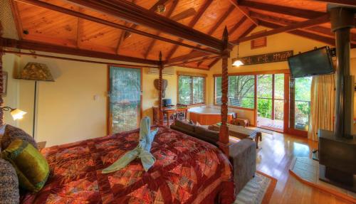a bedroom with a bed in a room with windows at Maleny Tropical Retreat in Maleny