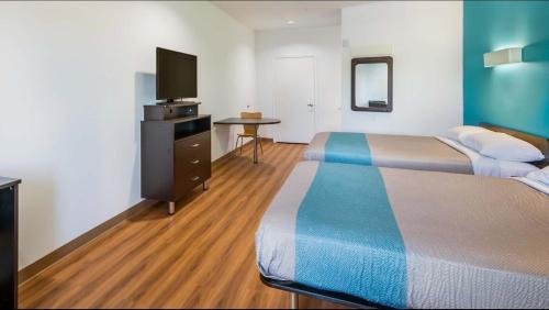 a hotel room with two beds and a flat screen tv at Motel 6-Channelview, TX in Channelview